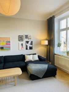 a living room with a blue couch and a window at Trendy and light 2 room apartment in SoFo, 65sqm in Stockholm