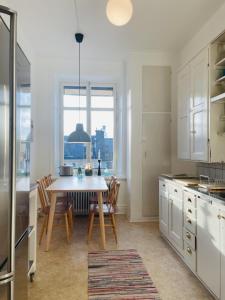 a kitchen with a table and chairs in a kitchen at Trendy and light 2 room apartment in SoFo, 65sqm in Stockholm