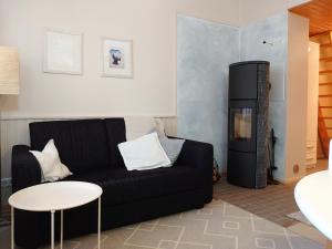 a living room with a black couch and a refrigerator at Rivitalon lomahuoneisto Tahkolla in Tahkovuori