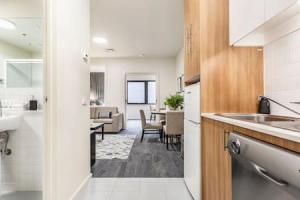 uma cozinha com um lavatório e uma sala de estar em VAQUAY Allure in Melbourne CBD em Melbourne