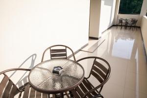 a glass table and chairs on a balcony at Saba Ayu Guest House in Bandung