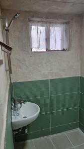 La salle de bains verte est pourvue d'un lavabo et d'une fenêtre. dans l'établissement Stay be oom, à Jeju