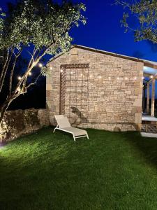 einem weißen Stuhl auf dem Gras vor einem Gebäude in der Unterkunft Le Dourdou del traouc in Bozouls