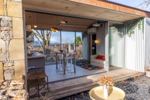 eine Glaserweiterung eines Hauses mit einer Küche und einem Tisch in der Unterkunft Le Dourdou del traouc in Bozouls