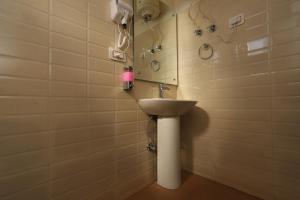 un bagno con lavandino e specchio di The Nest with open rooftop cafe Mecleodganj a Dharamshala