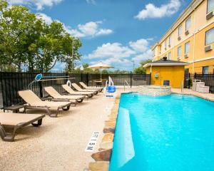 a swimming pool with lounge chairs next to a building at Sleep Inn & Suites New Braunfels in New Braunfels