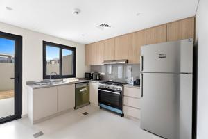 a kitchen with a refrigerator and a sink at Lovely 3BR Villa in Dubai EXPO in Dubai