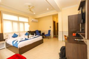 une chambre d'hôtel avec un lit et une télévision dans l'établissement The Nest with open rooftop cafe Mecleodganj, à Dharamshala
