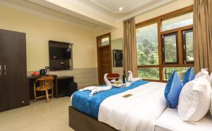 1 dormitorio con 1 cama grande y ventana grande en The Nest with open rooftop cafe Mecleodganj, en Dharamshala
