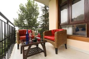 dwa krzesła i stół na balkonie w obiekcie The Nest with open rooftop cafe Mecleodganj w mieście Dharamsala