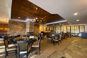 a restaurant with tables and chairs and a stone wall at Wyndham Minneapolis South Burnsville in Burnsville