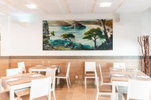 a dining room with tables and a painting on the wall at Apartamentos Loar in Ferreries