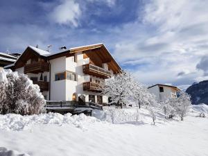 una casa nella neve con alberi innevati di Garni Tschutscherhof a Laion