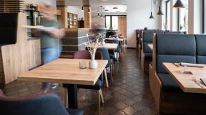 um restaurante com mesas de madeira e cadeiras azuis em Ferienpark Rursee em Simmerath