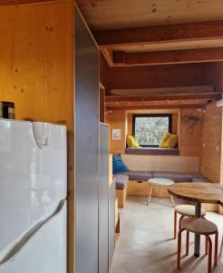 a kitchen and dining room with a refrigerator and a table at Tiny House Loule Algarve in Loulé