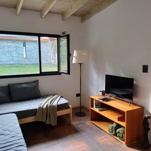 a room with a bed and a tv and a table at Ruca Reuemn in Mar del Plata