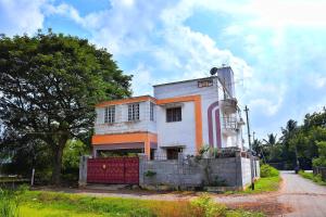 uma casa laranja e branca com uma cerca em frente em Revive Inn Pondy - Rooms & Villa em Pondicherry