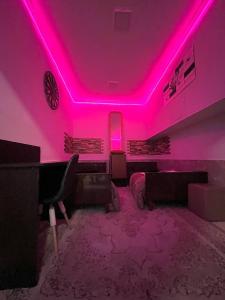 a pink room with a couch and a piano at Maria Hostel in Yerevan