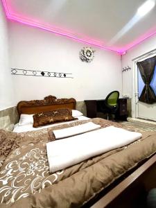 a bedroom with a large bed with pink lighting at Maria Hostel in Yerevan