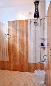 een badkamer met een houten muur en een emmer bij Revive Inn Pondy - Rooms & Villa in Pondicherry
