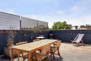 una mesa de madera y sillas en un patio en Superb duplex in prime area of London, en Londres