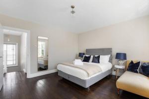 1 dormitorio blanco con 1 cama y 1 silla en Superb duplex in prime area of London, en Londres