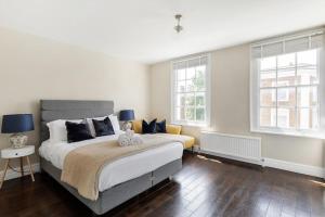 1 dormitorio con 2 camas y 2 ventanas en Superb duplex in prime area of London, en Londres