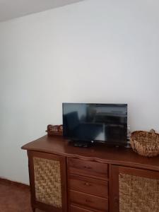 TV de pantalla plana en la parte superior de un armario de madera en Casa Amplio Jardín - Centro Maldonado, en Maldonado