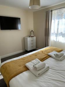 a bedroom with a large bed with towels on it at Lovely 2-Bed Apartment in Stroud in Stroud