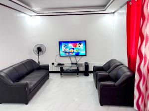- un salon avec deux canapés en cuir et une télévision à écran plat dans l'établissement Calapan Transient House 3-BedRoom near MALLS L26, à Calapan