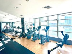 a gym with treadmills and ellipticals in a building at Sea View Cozy 2BHK Al Reem 6ppl - more than 10 days stay free transportation from Abu Dhabi Airport- in Abu Dhabi