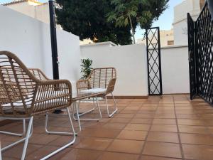 un grupo de sillas sentadas en un patio en Suite PLAYAMAR con jacuzzi, en Torremolinos