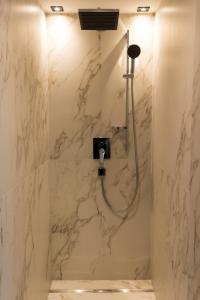 ナウダースにあるHaus Romanticaの大理石の壁のバスルーム(シャワー付)