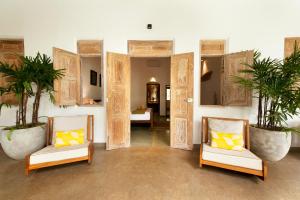阿漢伽馬的住宿－Nirbana Retreat，一间房间,配有两把椅子和两株盆栽植物