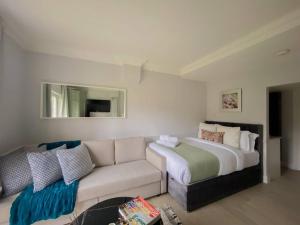 - un salon avec un grand lit et un canapé dans l'établissement Super comfy apartment in prime central London, à Londres
