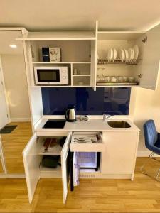 a small kitchen with a white desk with a microwave at Orbi City Hotel VIP - Batumi in Batumi
