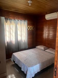 1 dormitorio con 1 cama con pared de madera en Casa do Kélvio, en Penha