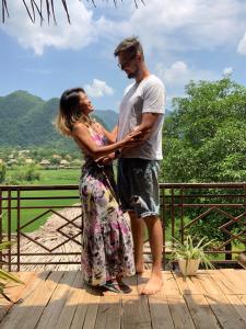 a man and a woman standing on a wooden deck at Green homestay Mai chau in Mai Chau