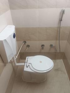 uma casa de banho com um WC branco e um chuveiro em Saraswati Sadan Homestay Ayodhya em Faizābād