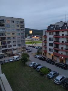 a parking lot with cars parked next to buildings at При митака in Pernik