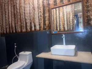 La salle de bains est pourvue de toilettes blanches et d'un lavabo. dans l'établissement Maweni CoralBay Beach Villa, à Kilindoni