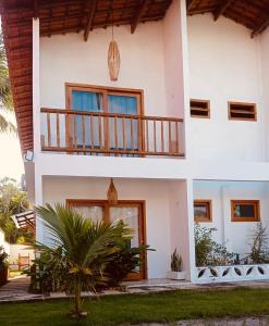 een groot wit huis met een balkon bij Villa Maria in Uruçuca