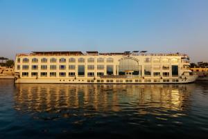 un gran edificio blanco sentado en el agua en Orient MS Grand Rose en Luxor