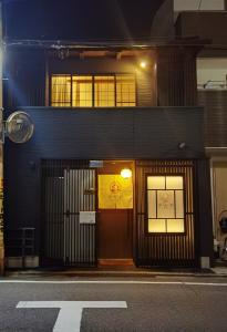 un edificio con una puerta con un letrero amarillo. en 秋桜館Cosmos, en Kioto