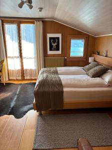 Un dormitorio con una cama grande y ventanas. en Alpina Boutique Hotel Interlaken - Ringgenberg - Adults only !, en Ringgenberg
