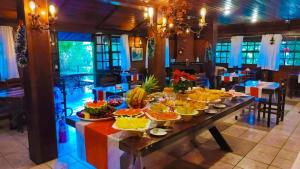 a long table with food on it in a restaurant at Pousada Le Lieu in Santo Antônio do Pinhal