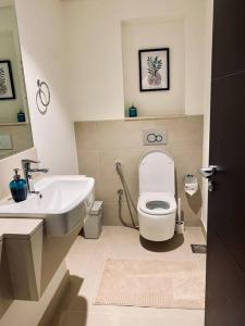 a bathroom with a white toilet and a sink at BJ's luxury Burj and Creek View 2 BR Apartment in Dubai