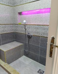 uma casa de banho com um chuveiro com um banco em شقه عالبحر بجوار هيلتون عاءلات فقط em Alexandria