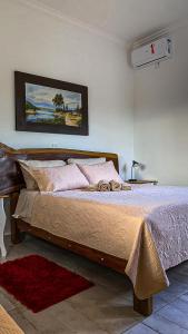 a bedroom with a large bed with pink pillows at Refúgio Vila da Glória in São Francisco do Sul +152 photos