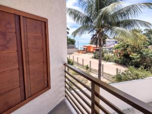 een balkon met een deur en een palmboom bij Pousada Pantanal in Prado